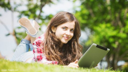 Young woman reading Kindle app on iPad